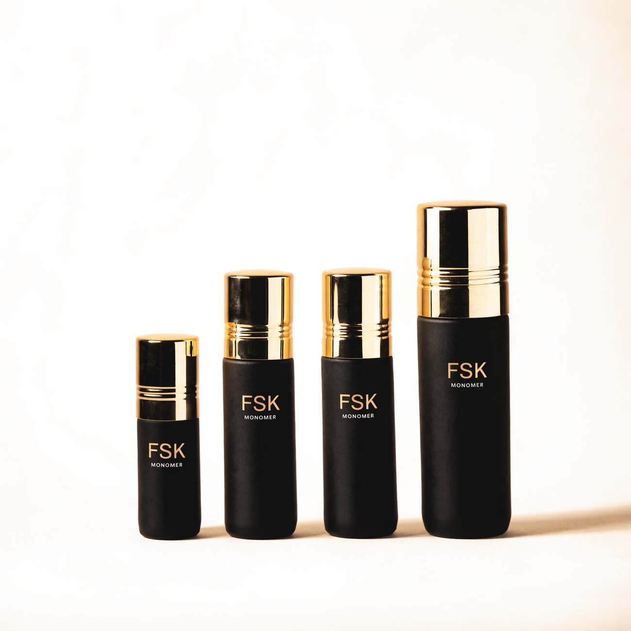 FSK Monomer in four sizes, matte black bottles with polished gold caps