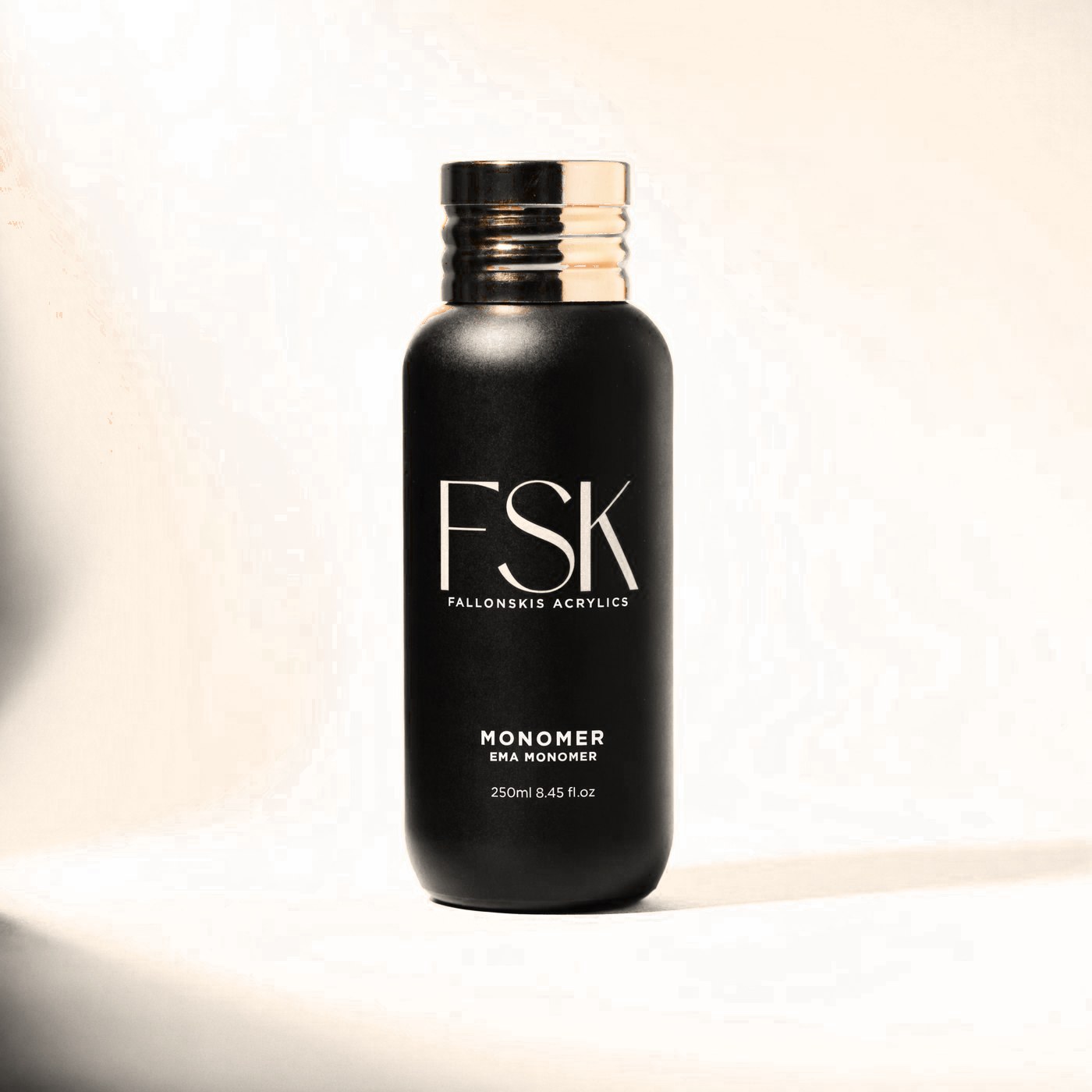 FSK Monomer, matte black bottle with a polished gold cap
